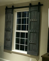Television room window adorned with custom barn shutters