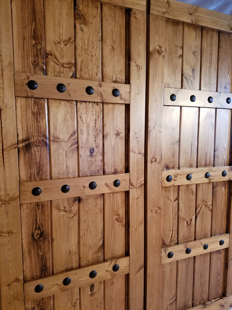 Barn shutter featuring wooden frame and metal studs