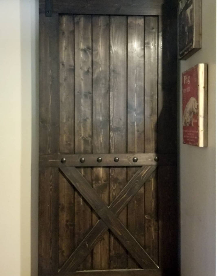 Custom Bottom Brace Interior Barn Door with wooden frame and metallic cross detail