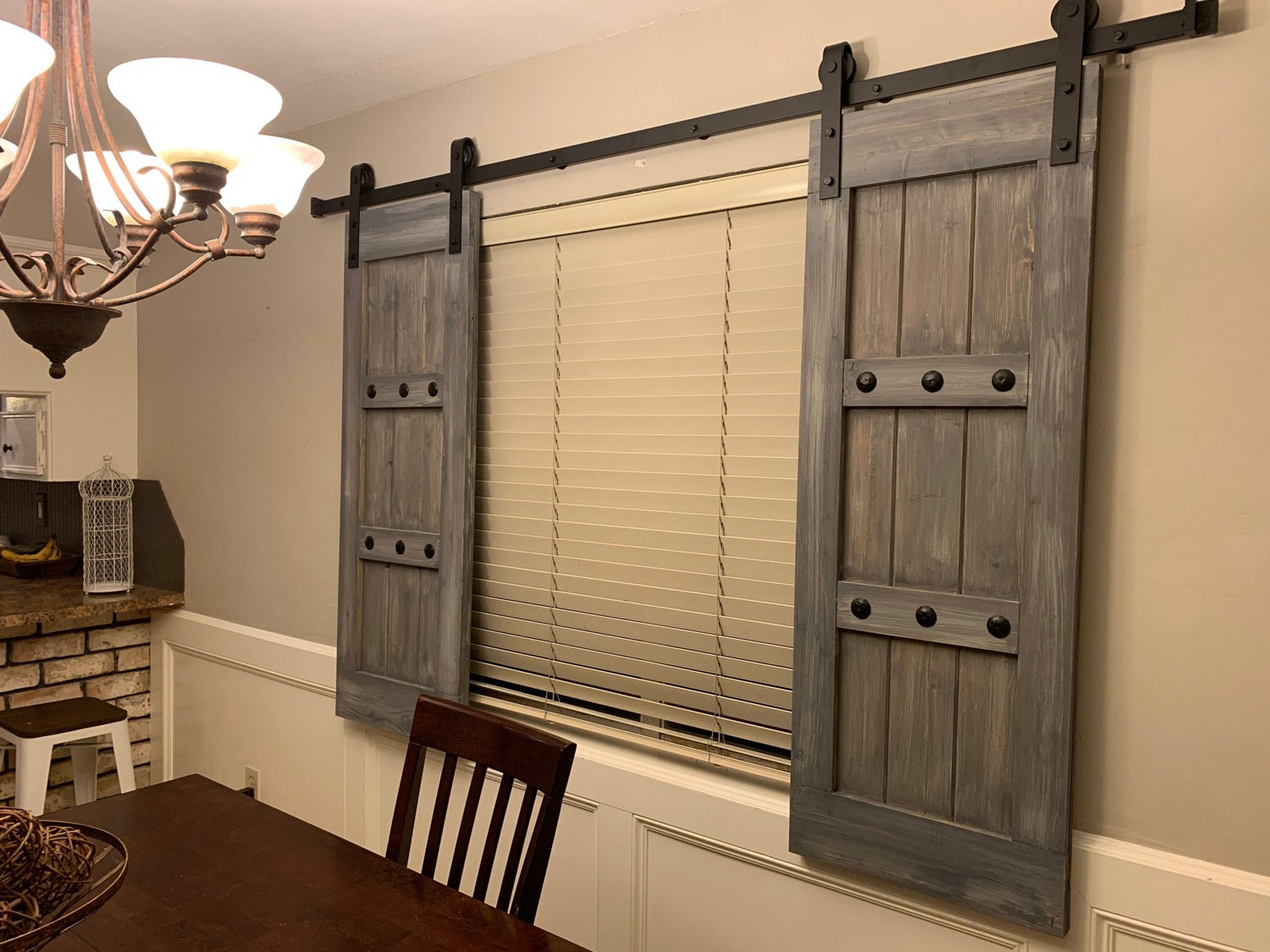 Dining room window featuring wooden barn shutters