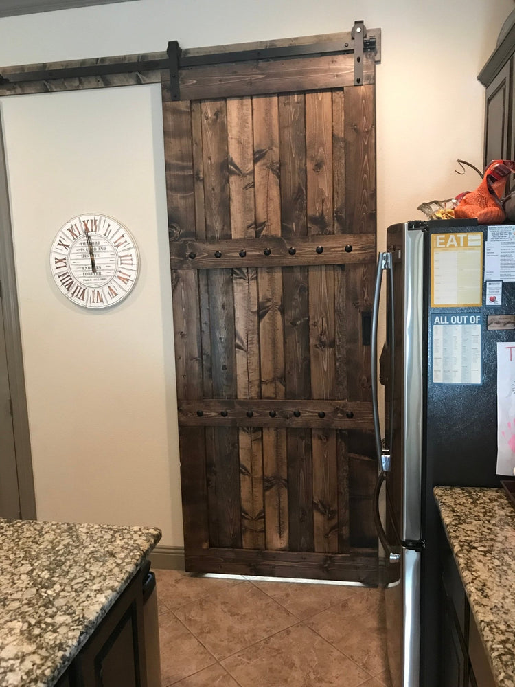 Kitchen featuring Rustic 84x33 Paneled Style Interior Barn Door and a clock