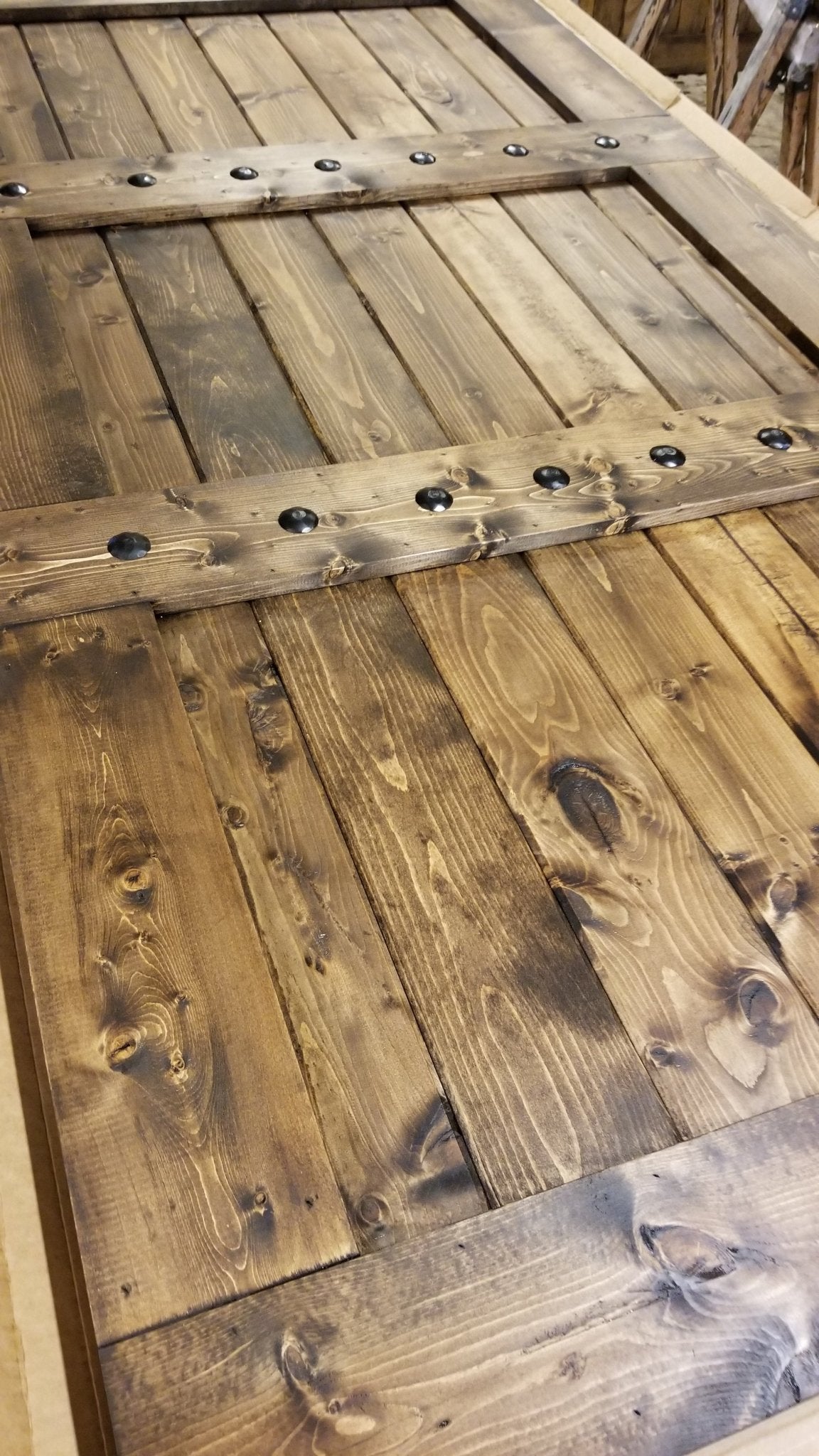 Rustic 84x33 Paneled Style Interior Barn Door next to a large wooden table