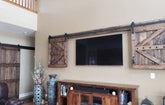 Special walnut Wall-mounted TV concealed with the wooden barn doors from the TV Hide package