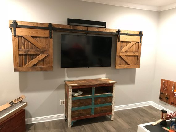 Custom TV cover with barn door design mounted on a wall