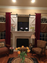 Living room scene with a fireplace and the TV Barn Door Package installed above it